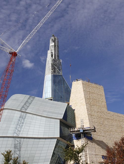 Workers on the Canadian Museum for Human Rights wait for the crane to raise the last piece of glass Thursday to be installed on the Museums Tower of Hope that stretches to 100 meters. Geoff Kirbyson story  (WAYNE GLOWACKI/WINNIPEG FREE PRESS) Winnipeg Free Press  Sept. 20  2012 CMHR