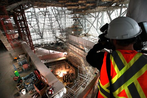 A member of the media takes some shots from one of the viewing areas out into the  "Cloud"  - a giant glass structure that surrounds the upper floors of the museum, down into the library sitting area Wednesday morning. Earlier building crews working on the Canadian Museum of Human Righs hoisted  the final piece of glass up to the chimney area of the Tower of Hope  which is 328 feet high on Wednesday morning. See Story Sept 20,  2012 (Ruth Bonneville/Winnipeg Free Press) CMHR