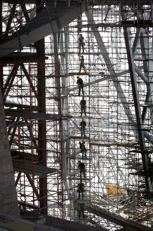 Construction crews working on the Canadian Museum of Human Rights form a human chain down each level of scaffolding as they take down upper levels of the structure piece by piece handing them down to each crew member one peice of piping at a time. The steel skeleton visible next to the museums glasswork contains 5,400 tonnes of steel, equivalent to the amount it would take to build 27 diesel electric locomotives. 

See Story Sept 20, 2012 (Ruth Bonneville/Winnipeg Free Press)  
Ruth Bonneville CMHR