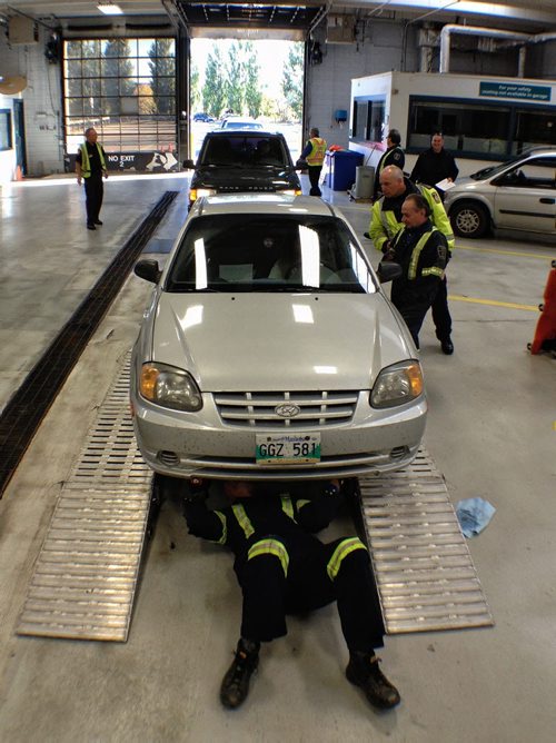 MPI Vehicle Standards Officer, Shaun Smart, inspects the underside of a car during a free motor vehicle inspection clinic at 420 Pembina Hwy.  120923 September 23, 2012 Mike Deal / Winnipeg Free Press
