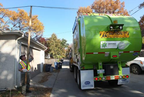 Working out the Bugs-A Emterra garbage collector uses a stick to raise wire so the  new garbage truck could clear  in rear lane of Elm St in River Heights- Today was day 01 of the City of Winnipegs new garbage and recycling program - See Jen Skeritt story October 01, 2012   (JOE BRYKSA / WINNIPEG FREE PRESS)