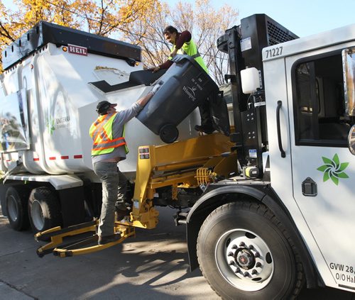 Working out the Bugs-Two Emterra garbage collectors fish out a garbage can that they accidentally threw out while empting in rear lane of Elm St in River Heights- thier clamp on the garbage can was to light  and they tossed the container inside the truck Today was day 01 of the City of Winnipegs new garbage and recycling program - See Jen Skeritt story October 01, 2012   (JOE BRYKSA / WINNIPEG FREE PRESS)