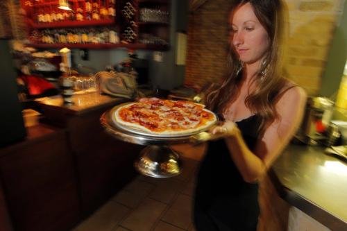 Corrientes Argentine Pizzeria review. Manager Cynthia Murray whisks by with a Crudo pizza inside the restaurant. Crudo pizza has Prosciutto, Buffalo Mozzarella and Sun Dried Tomato on it. October 9, 2012  BORIS MINKEVICH / WINNIPEG FREE PRESS