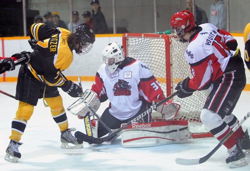 Brandon Sun 19102012 Brandon Switzer #7 of the Brandon Wheat Kings jousts for the puck with Sam Houston #18 of the Southwest Cougars in front of Cougars goalie Tyson Verhelst #30 during Manitoba AAA Midget Hockey League action at the Sportsplex on Friday evening. (Tim Smith/Brandon Sun)