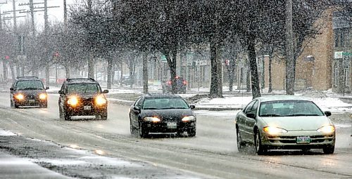 BORIS MINKEVICH / WINNIPEG FREE PRESS  070318 Cars face the snow on Main Street. The rain turned into snow in the afternoon giving Winnipeg another taste of winter. WEATHER STANDUP