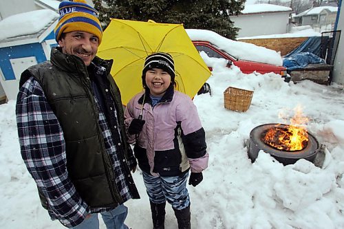 BORIS MINKEVICH / WINNIPEG FREE PRESS  070318 Nadia Fedon,8, holds her summer sunbrella in hopes of spring in her backyard with her dad Richard. They were sick and tired of the winter and started their first backyard fire of the year. WEATHER STANDUP.