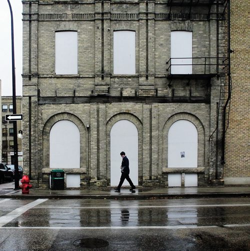 A pedestrian walks the wet streets of the Exchange District in Winnipeg's Downtown Tuesday morning.  121023 October 23, 2012 Mike Deal / Winnipeg Free Press
deal2012poy