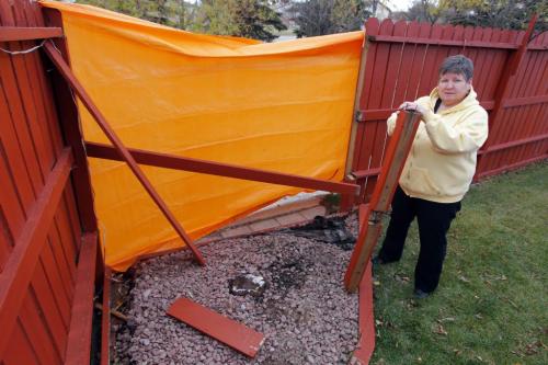 Terry Cannon who lives at 130 Southwalk Bay in South St. Vital had her fence torn apart by a garbage truck. Here she poses with some evidence. October 25, 2012  BORIS MINKEVICH / WINNIPEG FREE PRESS