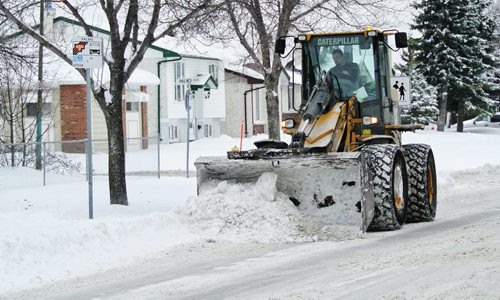 A front-end loader clears snow from around a bus stop on Burrows Monday morning. 121112 November 12, 2012 Mike Deal / Winnipeg Free Press