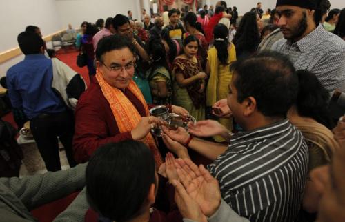 Diwali Puja event tonight at the Hindu Temple. Pundit Venkat Machiraju offering the sacred coconut water from the gods to the congrigation and offering his blessing, tikka (a red marking) on the fore head.  November 13, 2012  BORIS MINKEVICH / WINNIPEG FREE PRESS