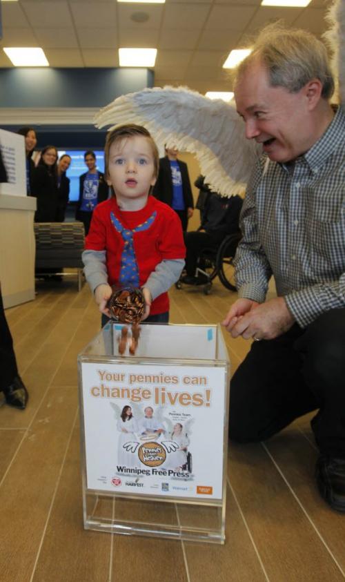 Kevin Rollason with his wings at the Sage Creek RBC event. Connel McGavock, 2.5 years old, donates his pennies. November 16, 2012  BORIS MINKEVICH / WINNIPEG FREE PRESS
