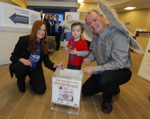 Kevin Rollason with his wings at the Sage Creek RBC event. Connel McGavock, 2.5 years old, donates his pennies. To the left is RBC Branch Manager Maxine Gromnisky. November 16, 2012  BORIS MINKEVICH / WINNIPEG FREE PRESS