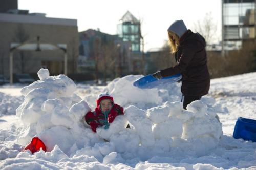 121118 Winnipeg - Wesley Bishops (age 2) takes a break from building a snow fort with his Aunt Jannetje Van Went, Sunday morning at The Forks. DAVID LIPNOWSKI / WINNIPEG FREE PRESS