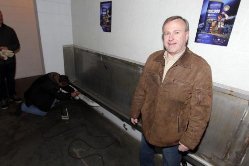 Leigh young (in front) bought the old piss trough from the mens bathroom at the old Winnipeg Stadium. Working on trough is Jim Nielsen on scene. November 19, 2012  BORIS MINKEVICH / WINNIPEG FREE PRESS