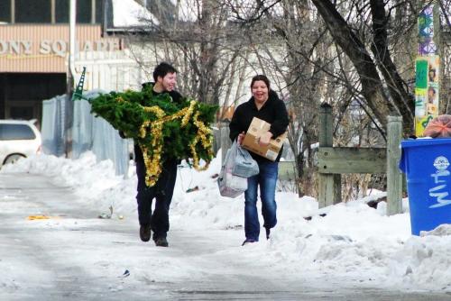 Getting into the holiday spirit a couple carries their artificial tree and box of ornaments to their apartment in west broadway.  121120 November 20, 2012 Mike Deal / Winnipeg Free Press