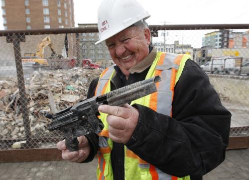 Mystery gun found at Shanghai Restaurant  demolition , Imrie Demolition owners Wayne Imrie looking from the sidewalk as his son with the backhoe dug through the rubble  looking for the mystery Thompson gun Äì the gun is a plastic toy replica  child's made by Mattel toys (sp)  KEN GIGLIOTTI  / WINNIPEG FREE PRESS  /  Nov 21 2012