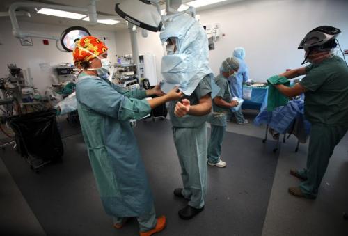 OR nurse Alison Bartel fits a sterile "hat" on Dr Thomas Turgeon as the Operation Walk team members prepare for for knee replacement surgery at Concordia Hospital Monday morning. August 13, 2012 - Phil Hossack / Winnipeg Free Press