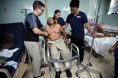 The morning after his surgery, Juan Canda's grimaces as he sinks into a chair after his first walk with physio-therapists Ian WIndle (left) Adrian Salonga. Juan received "bi-lateral" surgery, both knees were replaced. Phil Hossack / Winnipeg Free Press  October 25, 2012