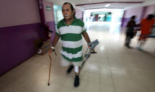 Using a single cane and carrying his crutches Juan Canda leaves the hospital in Managua for home four days after  "bi-lateral" surgery, both knees were replaced. Phil Hossack / Winnipeg Free Press  October 25, 2012