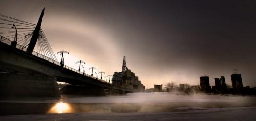 A crisp winter sun and it's dog set behind the Provencer Bridge as acold mist rises over the open Red River below.......Weather is, will be.... January 17, 2012- (Phil Hossack - Winnipeg Free Press)