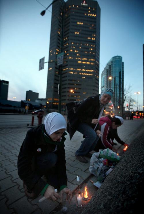 Syrian Winnipegers struggle to light candles along Main Street near Pioneer ave Thursday evening. a small vigil with about 30 participants marked the 1st anniversary of the Syrian Uprising. See release/story. March 15, 2012 - (Phil Hossack / Winnipeg Free Press)