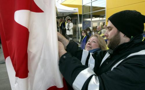 Dorothy Dobbie with Tree Canada (centre) raises the Canadian flag with some help during the grand opening of Winnipeg's IKEA Wednesday morning. 121128 - Wednesday, November 28, 2012 -  (MIKE DEAL / WINNIPEG FREE PRESS)