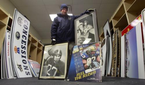 Jeffrey Bannon, Winnipeg Football Club Director of Marketing with photographs of Bomber all time greats Leo Lewis and  #27 Jack Jacobs along with some of the items for sale Thursday in the Canad Inn Stadium.  Ed Tait story.  (WAYNE GLOWACKI/WINNIPEG FREE PRESS) Winnipeg Free Press  Nov. 28   2012