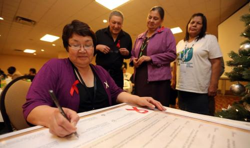 Rebecca Kudloo, from the Pauktuutit Inuit Women of Canada, signs a proclaimation at the Aboriginal Aids Awareness Week launch at the Delta Hotel in front of Art Zoccole, Chair of the Canadian Aboriginal Aids Network, Vera Pawis-Tobobondung, President of the National Association of Friendship Centres and Doris Peltier, representing Michelle Audette, the President of the Native Women's Association of Canada, Saturday, December 1, 2012. (TREVOR HAGAN/WINNIPEG FREE PRESS) geoff kirbyson story