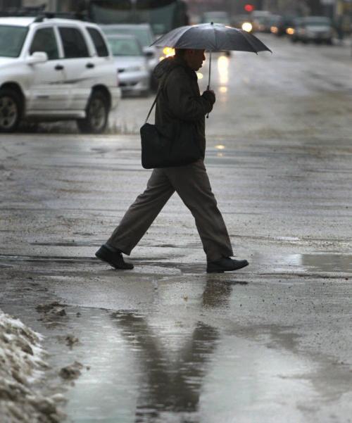 Umbrellas were out on Broadway on a rainy Monday morning. (WAYNE GLOWACKI/WINNIPEG FREE PRESS) Winnipeg Free Press  Dec.3   2012