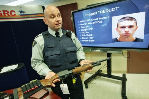 Selkirk RCMP constable Paul Human holds one of the many long guns that were seized during the 12-week-old investigation, Project Deduct in the Selkirk headquarters Monday afternoon.  121203 December 03, 2012 Mike Deal / Winnipeg Free Press