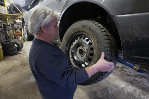 Tim Howell of Curtis Tire Service prepares to install a new  snow tire .- See Gabrielle Giroday story- Dec 03, 2012   (JOE BRYKSA / WINNIPEG FREE PRESS)