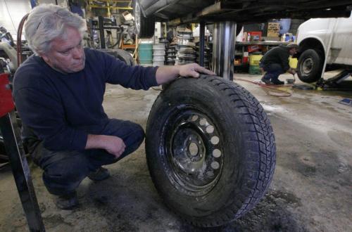 Tim Howell of Curtis Tire Service prepares to install a new  snow tire .- See Gabrielle Giroday story- Dec 03, 2012   (JOE BRYKSA / WINNIPEG FREE PRESS)