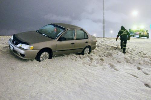 A tow truck operator pulls a car out of a ditch on the Perimeter at Lagimodiere Blvd, Monday, December 3, 2012. (John Woods/Winnipeg Free Press)
