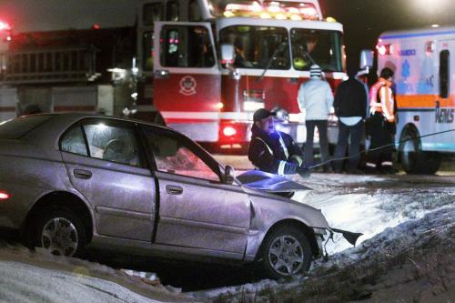 A tow truck operator pulls a car, which was involved in a head-on collision, out of a ditch on Ravelston Avenue West, just north of Almey, Monday, December 3, 2012. (John Woods/Winnipeg Free Press)