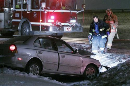 A tow truck operator pulls a car, which was involved in a head-on collision, out of a ditch on Ravelston Avenue West, just north of Almey, Monday, December 3, 2012. (John Woods/Winnipeg Free Press)