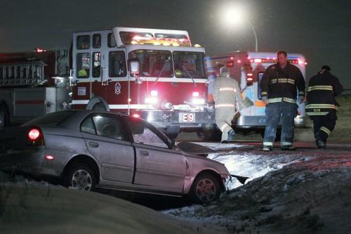 Firefighters attend a car, which was involved in a head-on collision, out of a ditch on Ravelston Avenue West, just north of Almey, Monday, December 3, 2012. (John Woods/Winnipeg Free Press)