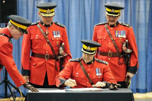 With RCMP Commissioner Bob Paulson (left) and Assistant Commissioner Bill Robinson (right) watching, Assistant Commissioner Kevin Brosseau signs the Change of Command Parchment as he is made the new commander of RCMP "D" Division during a change of command ceremony at the Minto Armouries. He replaces Assistant Commissioner Bill Robinson who now resides in Edmonton, Alberta.  121206 December 06, 2012 Mike Deal / Winnipeg Free Press