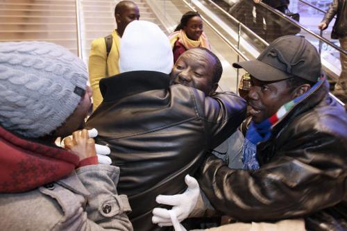 December 4, 2012 - 121204  -  Congolese refugee Bahati Mulimbwa (c) is swarmed by friends and family as he and his family arrive at Winnipeg's James Richardson International Airport Tuesday December 4, 2012. The family of nine fled the Congo in 2002 and have been sponsored into Canada by First Presbyterian Church. John Woods / Winnipeg Free Press