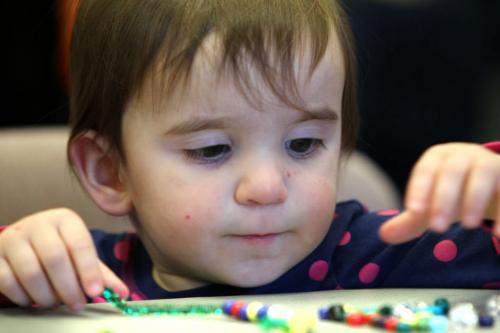 Two year old Lucy Parkes-Slvis strings some beads together while attending the children's activity room at the annual open house of the Manitoba  legislature Saturday afternoon with her family. Standup weather photo. Dec 08, 2012, Ruth Bonneville  (Ruth Bonneville /  Winnipeg Free Press)