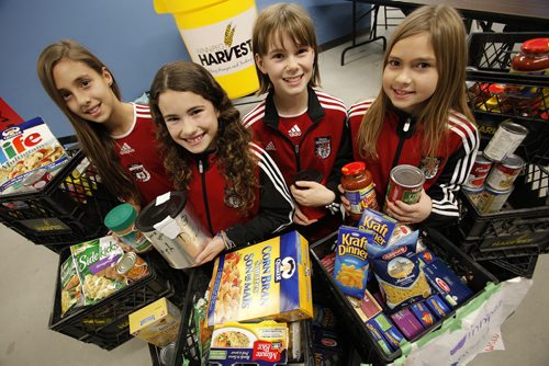 (L to R) Abi Dueck, Bianca Bucci, Elise Coates and Kiaja Dueck of the Winnipeg South End United under 11 soccer program are photographed with some of the food and the money they collected for Winnipeg Harvest at the University of Manitoba, Saturday, December 8, 2012. Last year they collected 800 pounds and this year they are going for 1000 pounds. (John Woods/Winnipeg Free Press)