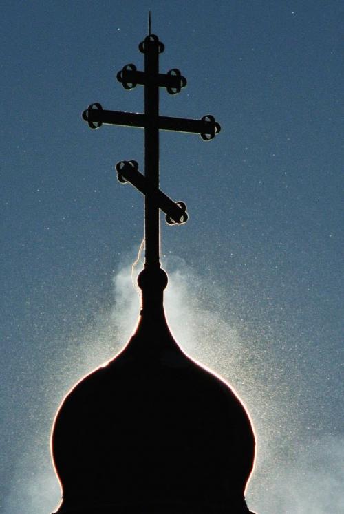 Steam and blowing snow swirl around one of the crosses on the Holy Trinity Ukrainian Orthodox Metropolitan Cathedral that is silhouetted by the sun early Sunday morning.   121209 December 09, 2012 Mike Deal / Winnipeg Free Press
