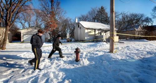 A RCMP Officer and a possible family member or friend of the family walk in front of  322 Taylor Ave Tuesday morning where a 51 year old women died in a house fire. in Selkirk Manitoba Monday night. See story. Dec 11, 2012, Ruth Bonneville  (Ruth Bonneville /  Winnipeg Free Press)