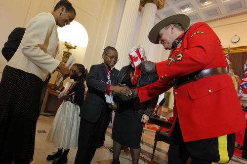 30 people became Canadian Citizens today at the Leg. The Nkana Bassi family of 4 were sworn in. 9 Year old Junior shakes hands with an RCMP officer. Sister Lea and mother Carole in photo too. December 12, 2012  BORIS MINKEVICH / WINNIPEG FREE PRESS