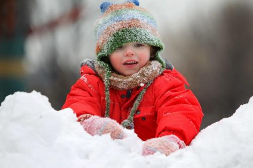 Three year old Mattejas Kafka climbs up a snow hill while trying to keep his hat out of his eyes while at the Forks Thursday afternoon with his family. Standup photo. Dec 13, 2012, Ruth Bonneville  (Ruth Bonneville /  Winnipeg Free Press)