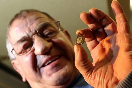 Malcolm Taylor holds a 1913 Winnipeg Rodeo pin that was sent to him from an old Navy buddy who found it while digging around in Nottinghamshire, England, Friday, December 14, 2012. (TREVOR HAGAN/WINNIPEG FREE PRESS)