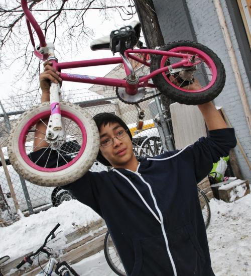 Seth Belmore (left), 12, of the University of Winnipeg Students Association Bike Lab holds up one of the bikes he fixed for a photo his friend Dave Dorning is taking during the Cycle of Giving at the Atomic Centre on Logan Avenue. Dozens of mechanics have been working for the last twenty-four hours fixing up over 200 bicycles for Winnipeg children in need in the second annual event.  121216 December 16, 2012 Mike Deal / Winnipeg Free Press
