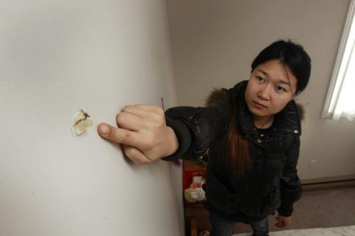Kate Cheng, wants to move after a bullet flew through the wall of her apartment on Pembina Hwy, she is in her bedroom with a bullet hole above her bed. Gabrielle Giroday story   (WAYNE GLOWACKI/WINNIPEG FREE PRESS) Winnipeg Free Press  Dec.17   2012