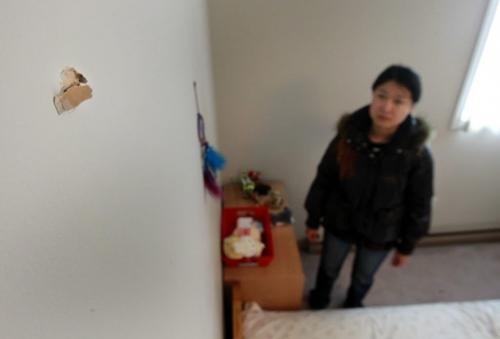 Kate Cheng, wants to move after a bullet flew through the wall of her apartment on Pembina Hwy, she is in her bedroom with a bullet hole above her bed.Gabrielle Giroday story   (WAYNE GLOWACKI/WINNIPEG FREE PRESS) Winnipeg Free Press  Dec.17   2012