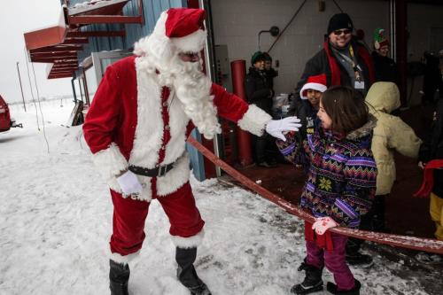 Santa (Doug Speirs) high-fives excited school kids as he arrives after a flight on the STARS helicopter. Around 150 kids from three Winnipeg School Division elementary schools, Strathcona, Mulvey and Dufferin, got to have lunch in the Winnipeg James Armstrong Richardson International Aiport's firehall where Santa just happened to be testing out the STARS helicopter. Fred Penner was on hand to perform some music too. 121217 - Monday, December 17, 2012 -  (MIKE DEAL / WINNIPEG FREE PRESS)