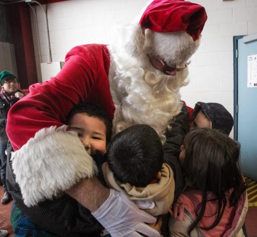 Santa (Doug Speirs) gets in lots of hugs from excited school kids as he arrives after a flight on the STARS helicopter. Around 150 kids from three Winnipeg School Division elementary schools, Strathcona, Mulvey and Dufferin, got to have lunch in the Winnipeg James Armstrong Richardson International Aiport's firehall where Santa just happened to be testing out the STARS helicopter. Fred Penner was on hand to perform some music too. 121217 - Monday, December 17, 2012 -  (MIKE DEAL / WINNIPEG FREE PRESS)